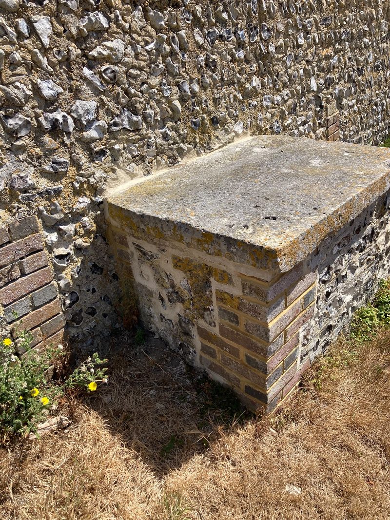 A stone cap on a brick and flint pier